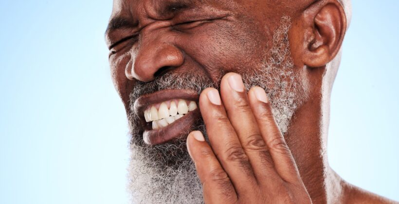 Man clenching teeth and holding his jaw - how do I stop teeth grinding - Midland Bay Dental.